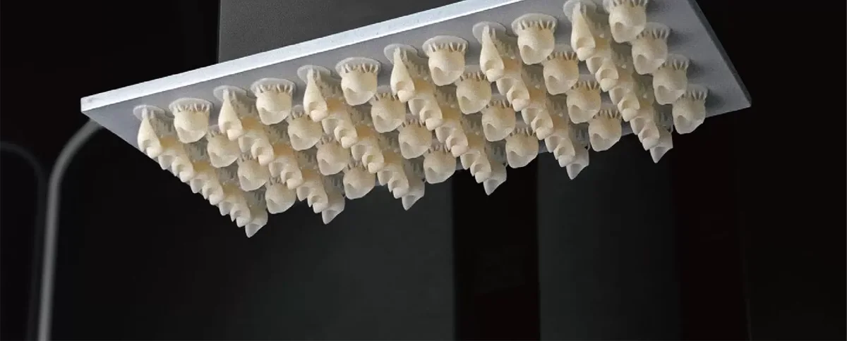 Batch of tooth-colored printed crowns on a build platform
